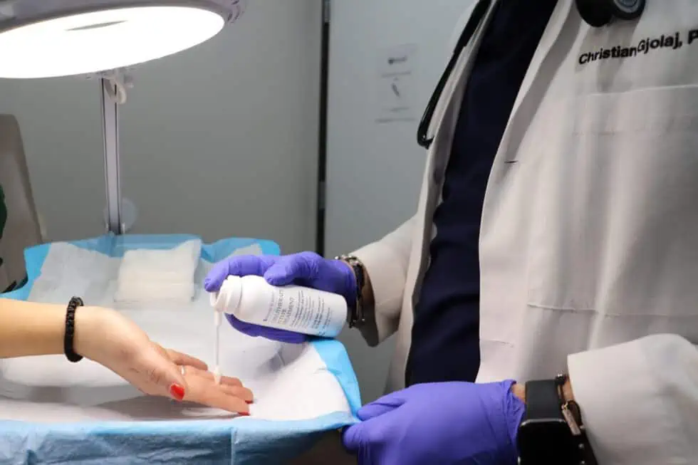 doctor holding a bottle over a woman's hand